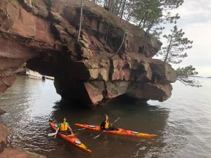 Joe and Emily Kayaking under a Red Cliff arch