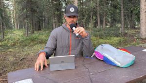 Joe recording a podcast in Alaska campsite