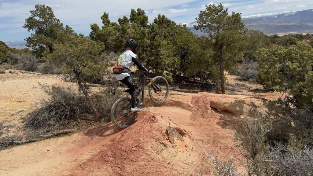 Mountain biking over a jump on the Spinal Tap tail in Richfield Utah.