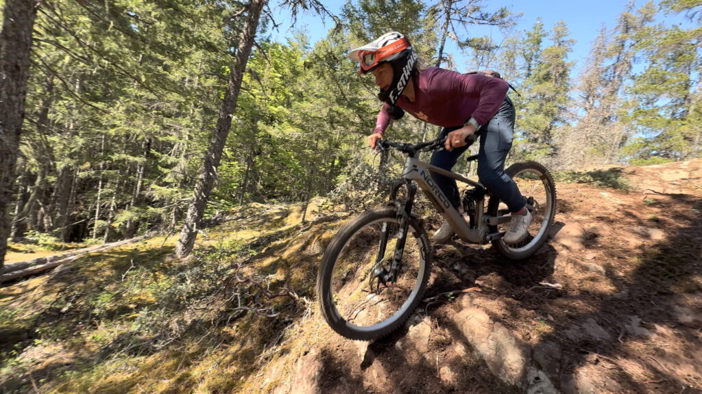 Emily ripping the Norco TQ down some chuck and not liking the Shimano Deore brakes.